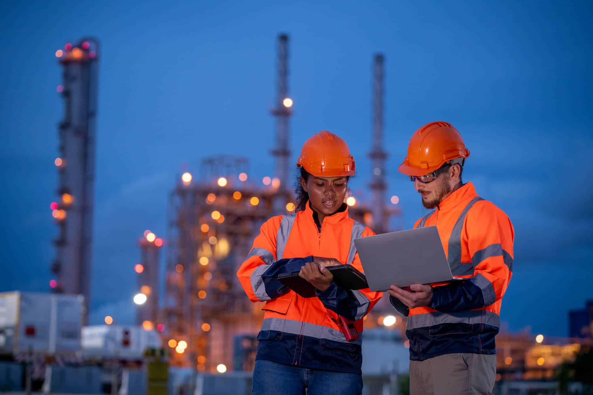 employees working together with computer wearing safety gear