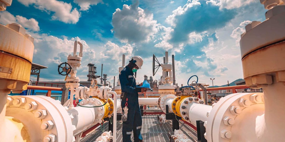 Male worker inspection at steel long pipes and pipe elbow in station oil factory during refinery valve of visual check record pipeline tank oil and gas industry